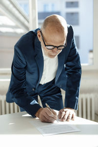 Businessman signing document on desk in office