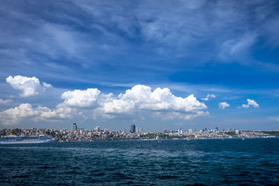 Scenic view of sea by buildings against sky