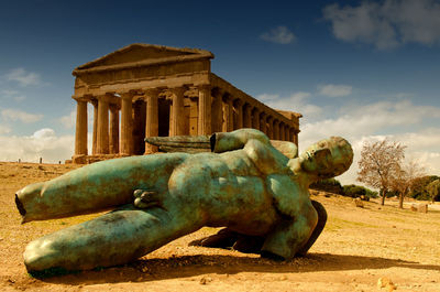Statue of historical building against cloudy sky