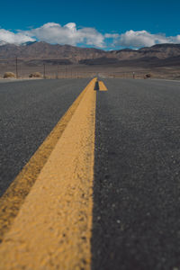 Road by mountains against sky