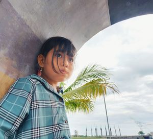 Portrait of boy standing against sky