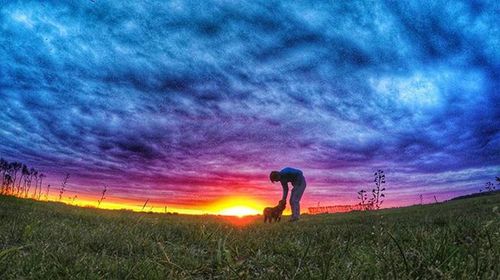 Scenic view of grassy field against cloudy sky