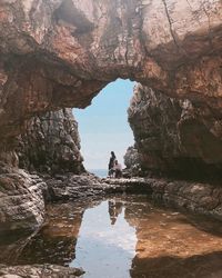 Couple standing on rock formation in water