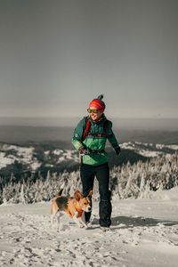 Woman running with dog on snow