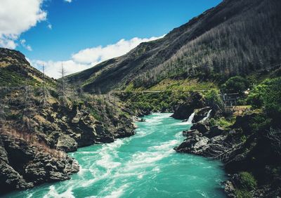 Tranquil view of blue river against mountain ranges