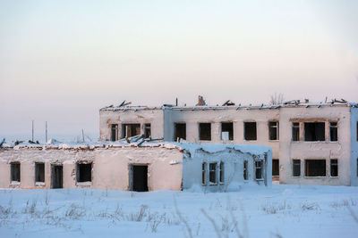 Snow covered building against sky