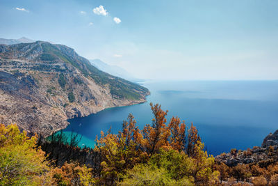 Scenic view of sea and mountains against sky