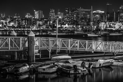 Boats moored at harbor in city at night
