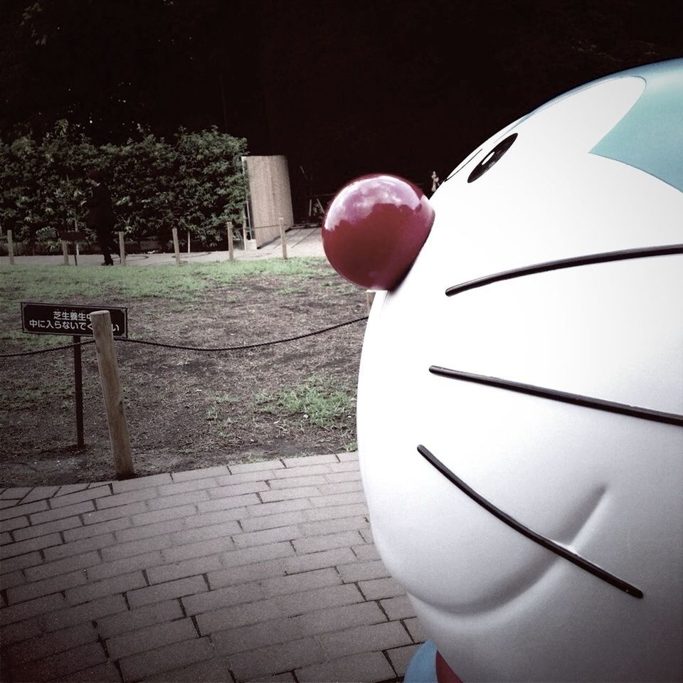 red, balloon, outdoors, hanging, no people, tree, day, transportation, circle, sphere, communication, mid-air, built structure, close-up, sunlight, street, road sign, celebration, animal representation, building exterior