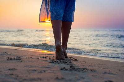 Low section of woman standing on beach