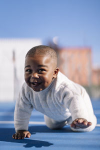 Happy cute baby crawling on sports court