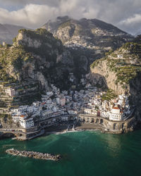 High angle view of townscape by sea against sky