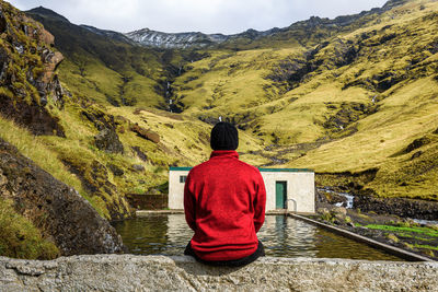 Rear view of man sitting on mountain road