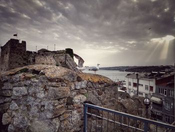 Buildings by sea against sky in city