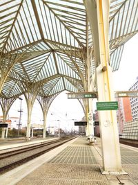 Railroad station platform in city against sky