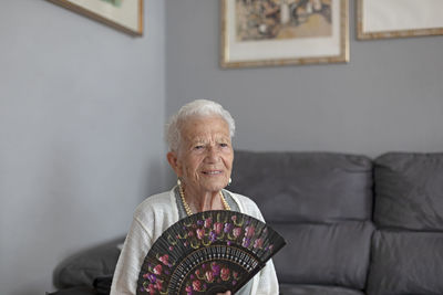 Portrait of smiling woman sitting on sofa at home