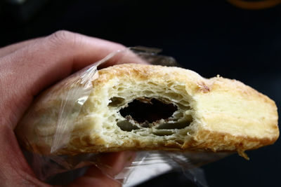 Hand holding bread over black background