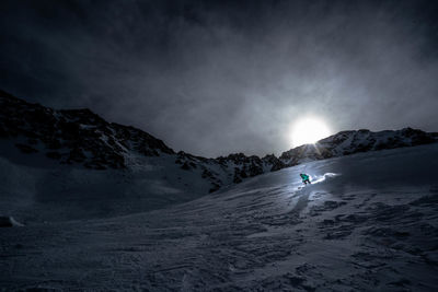 Low angle view of person skiing on snow covered mountain