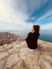 Rear view of woman looking at sea against sky