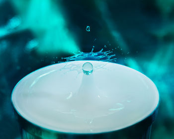 Close-up of water splashing in blue glass