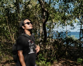 Portrait of young man standing in forest