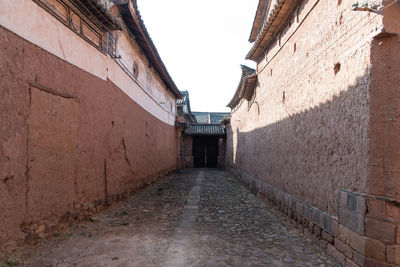 Narrow alley amidst buildings against sky