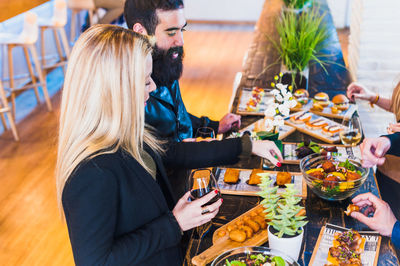 High angle view of friends having food at table in restaurant