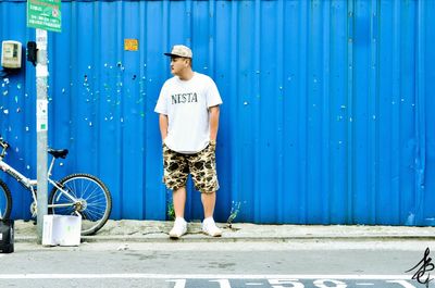 Full length of man standing in front of blue door