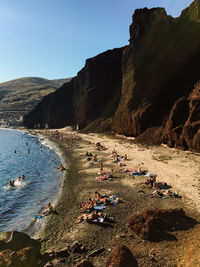 Group of people on beach against clear sky