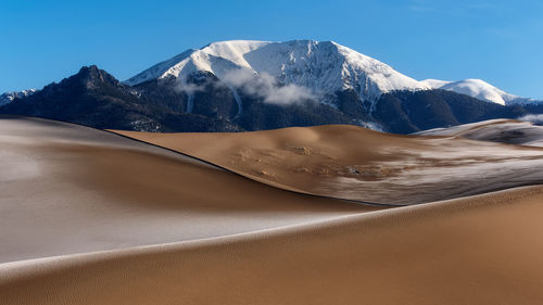 Scenic view of desert against blue sky