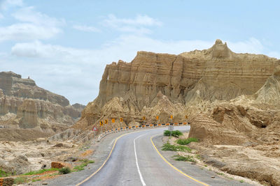 Road leading towards mountains against sky