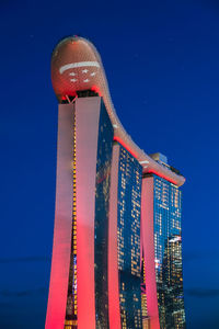 Low angle view of illuminated tower against blue sky