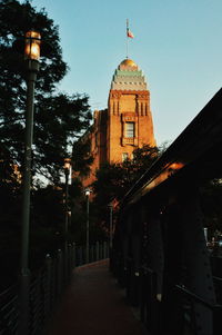 Street amidst buildings against sky at dusk