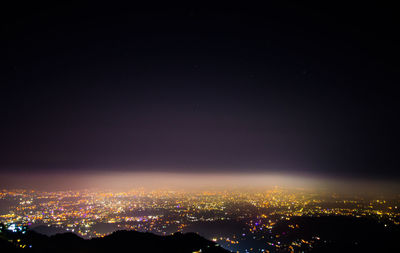 Aerial view of illuminated buildings in city at night