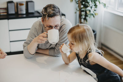 Mother and daughter drinking at table