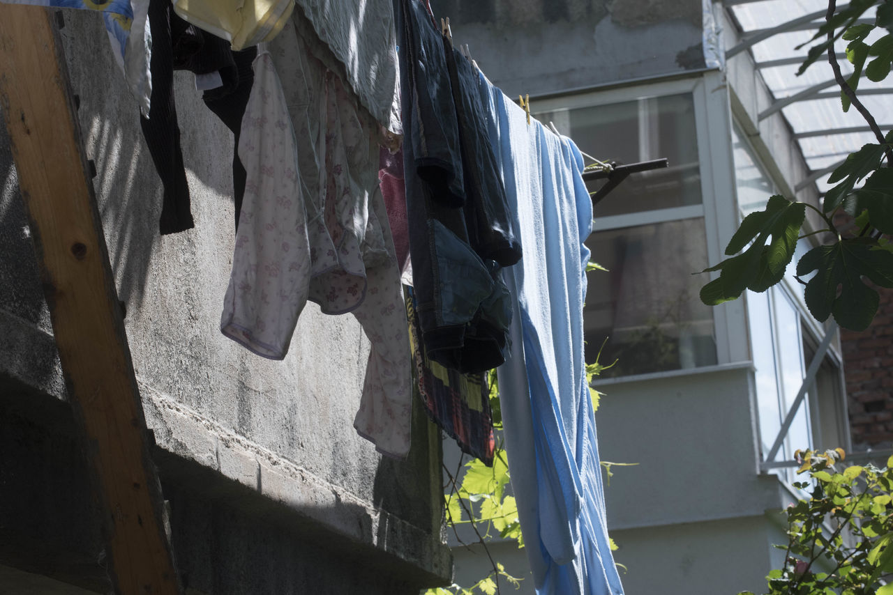 LOW ANGLE VIEW OF CLOTHES DRYING OUTSIDE HOUSE