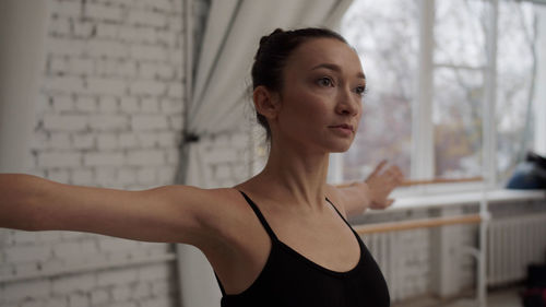 Ballet dancer stretching against wall