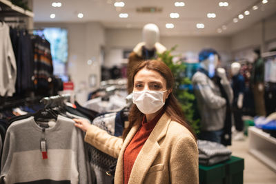 Woman wearing mask while looking at garments