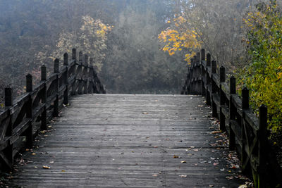 Wooden footbridge over footpath during autumn