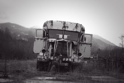 Abandoned truck on field against clear sky