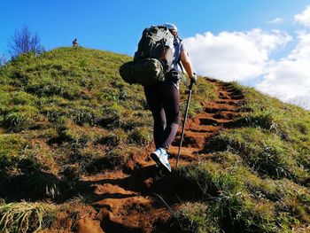 Full length rear view of man hiking on mountain