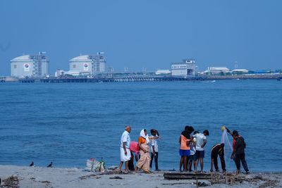 People at beach against clear sky