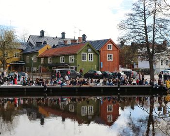 Group of people in canal by buildings in city