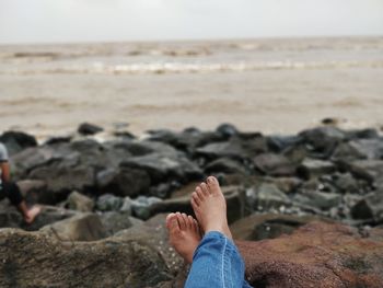 Low section of person on rock at beach