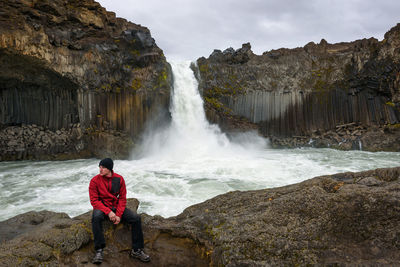 Rear view of man looking at waterfall