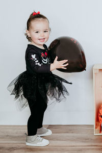 Portrait of cute girl standing against white background