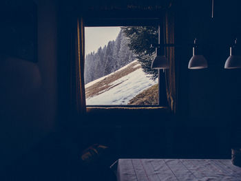 Mountain seen through window during winter