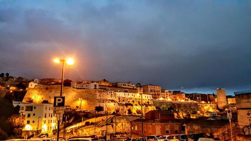 Illuminated buildings in city against sky at night