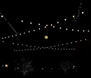 Low angle view of illuminated christmas lights against sky at night