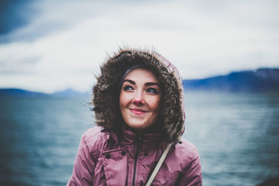 Portrait of smiling woman against sea against sky